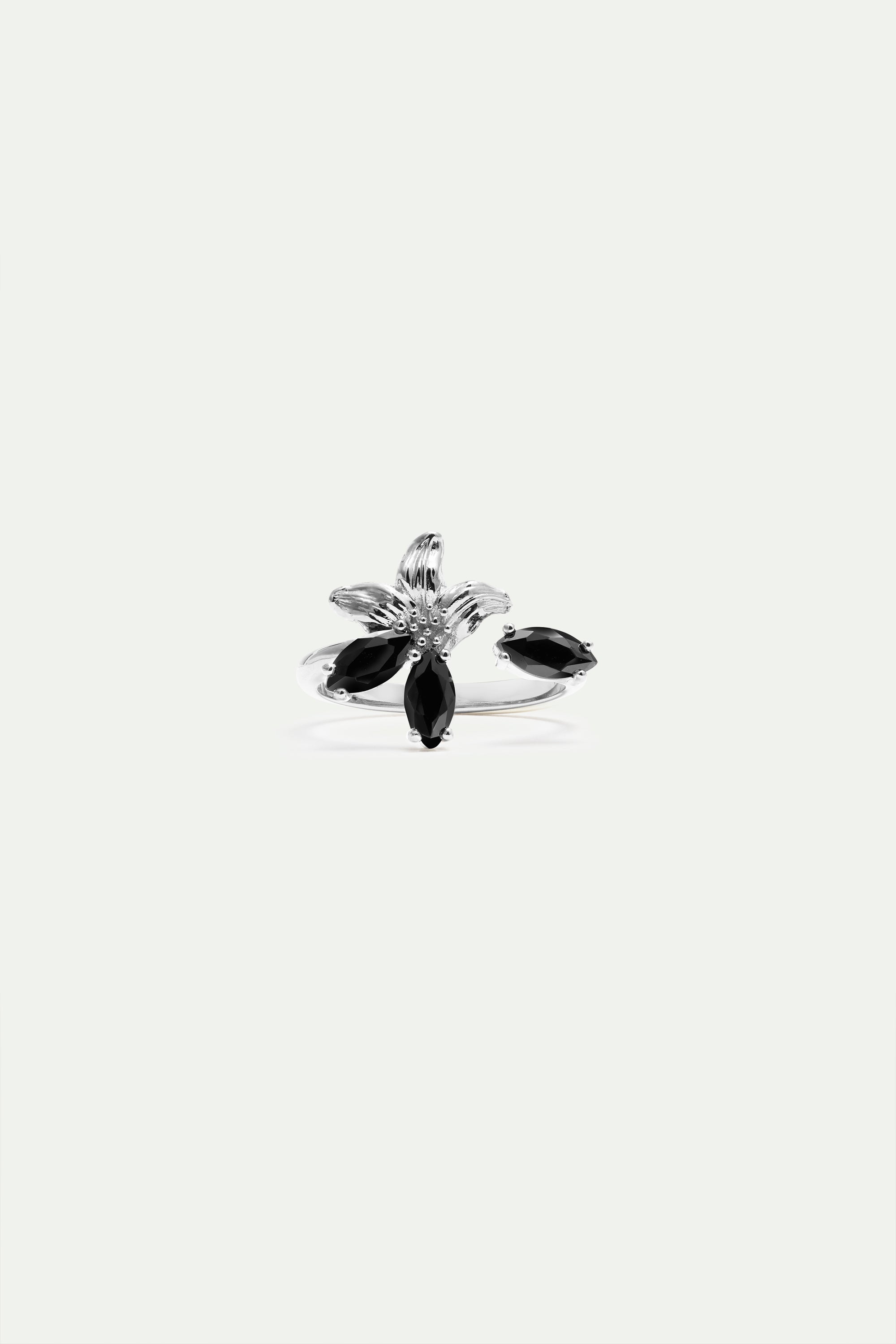 Silver-toned adjustable ring with a central floral design, featuring black marquise-cut stones and a textured centre.