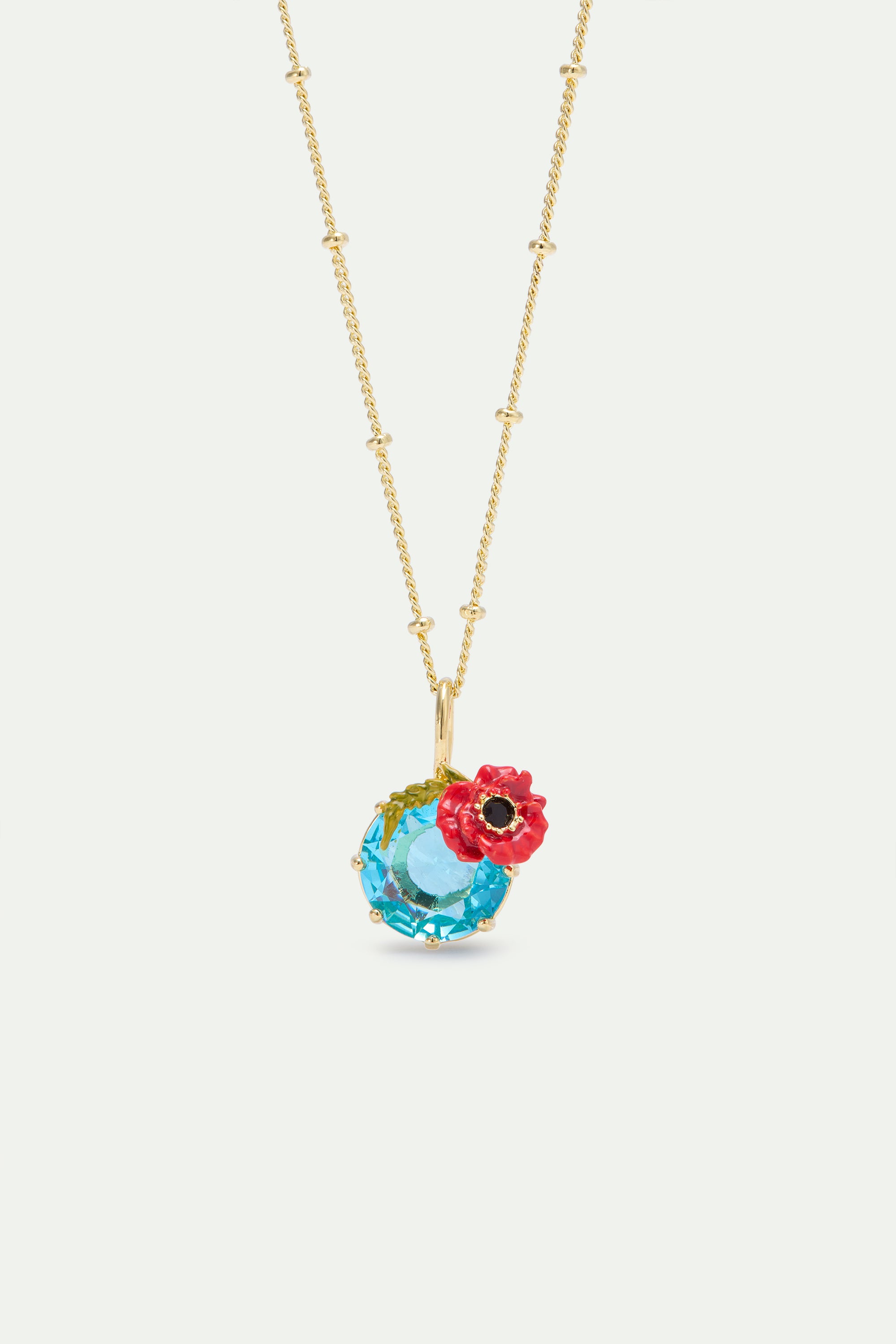 Gold-toned beaded chain necklace with a light blue faceted crystal pendant and a red and black enamel poppy flower.