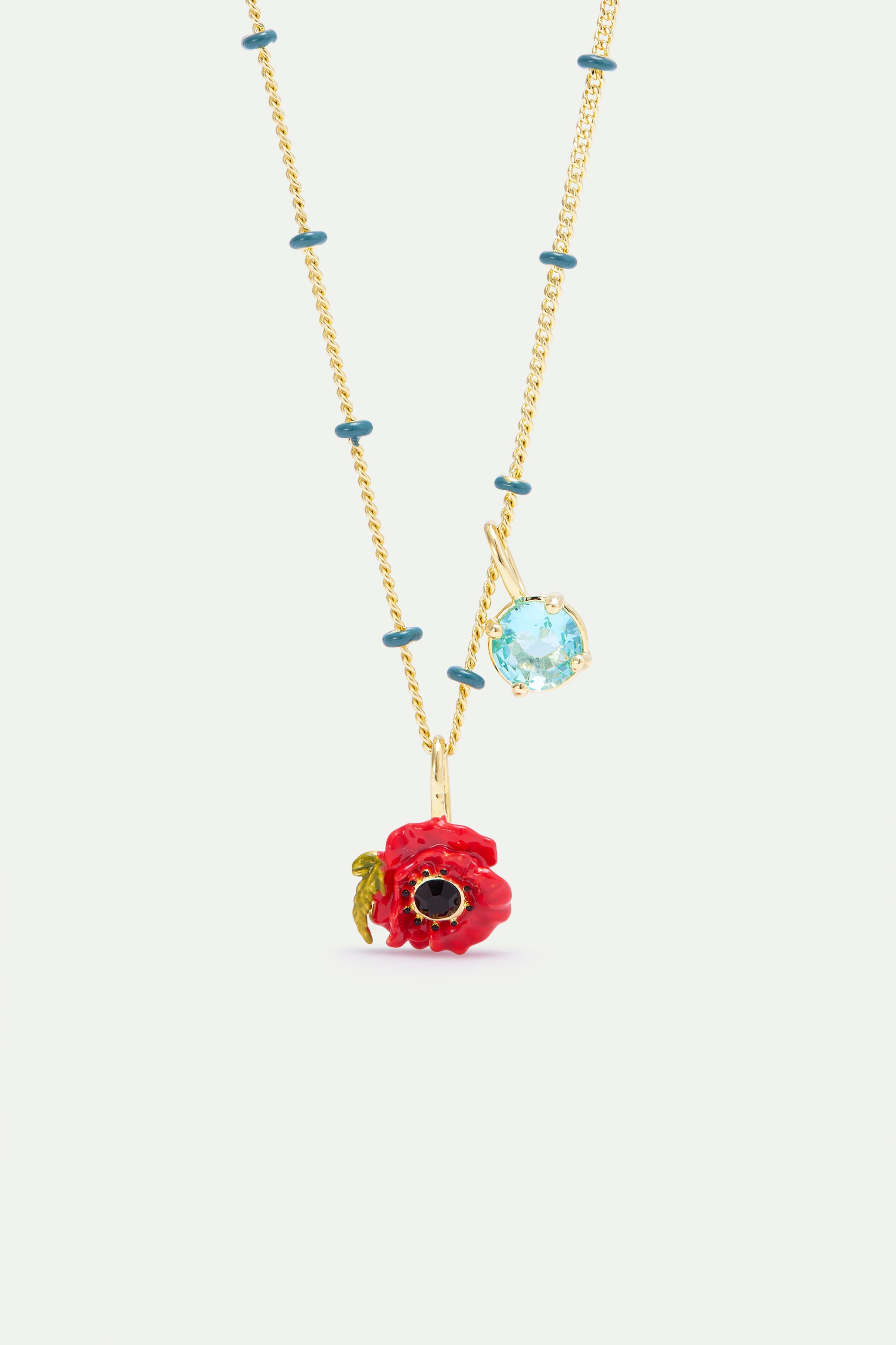 Gold-toned necklace with teal beads, a red enamel poppy flower pendant with black centre, and a light blue faceted gemstone p
