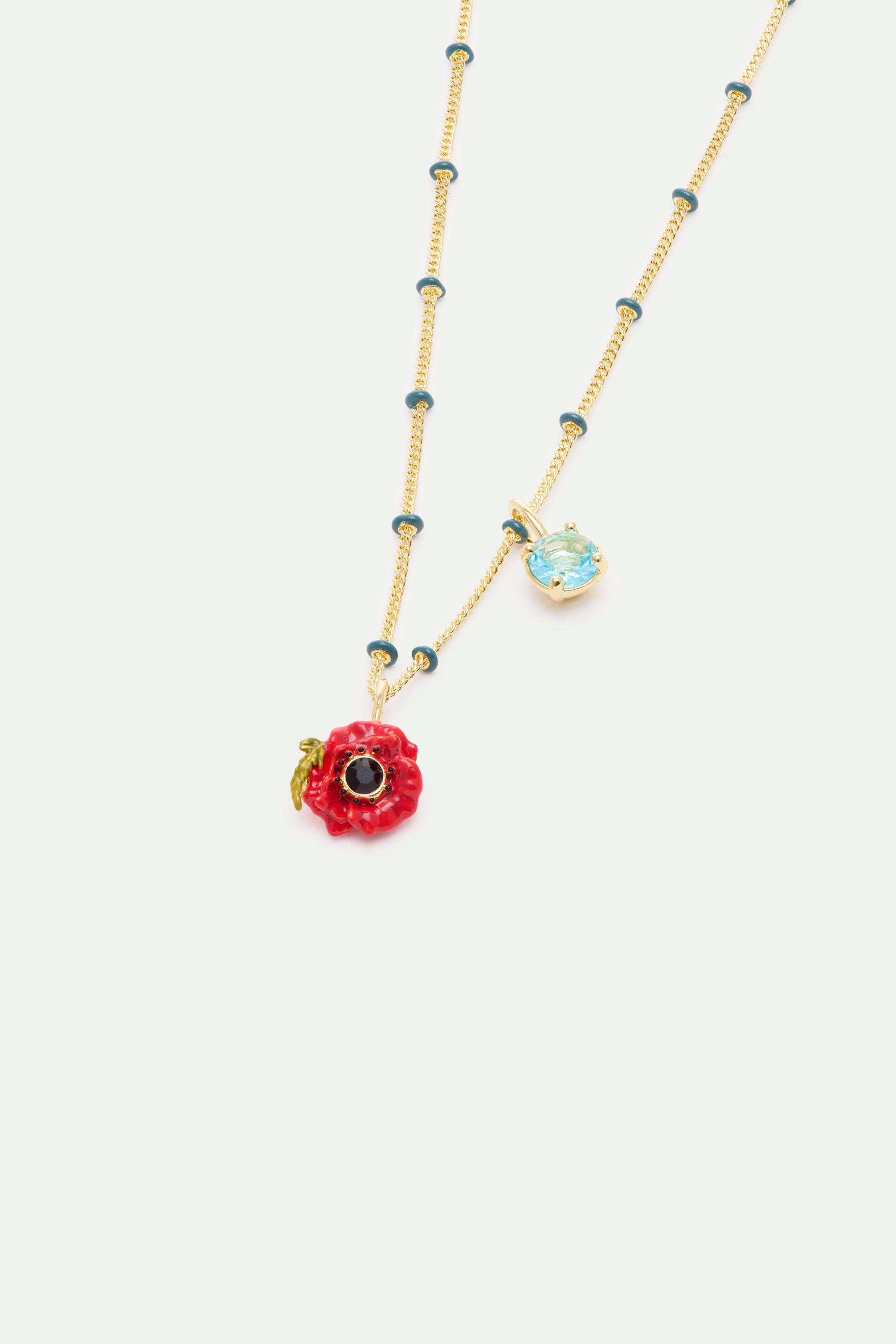 Gold-toned chain with teal beads, featuring a red poppy pendant with a black center and a light blue faceted gemstone pendant