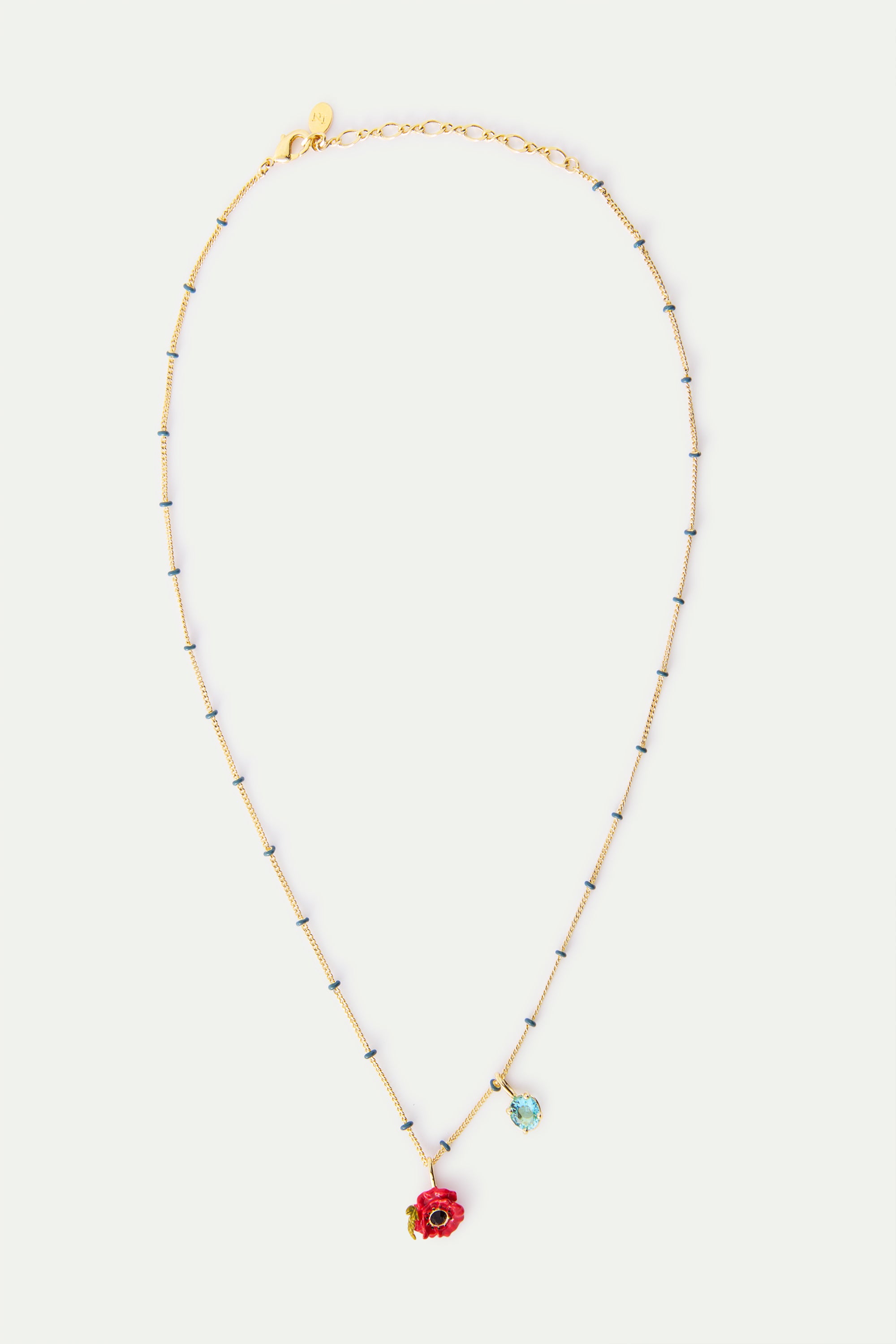 Gold-toned necklace with small dark blue beads, featuring a red poppy pendant with a black center and a light blue oval gem p
