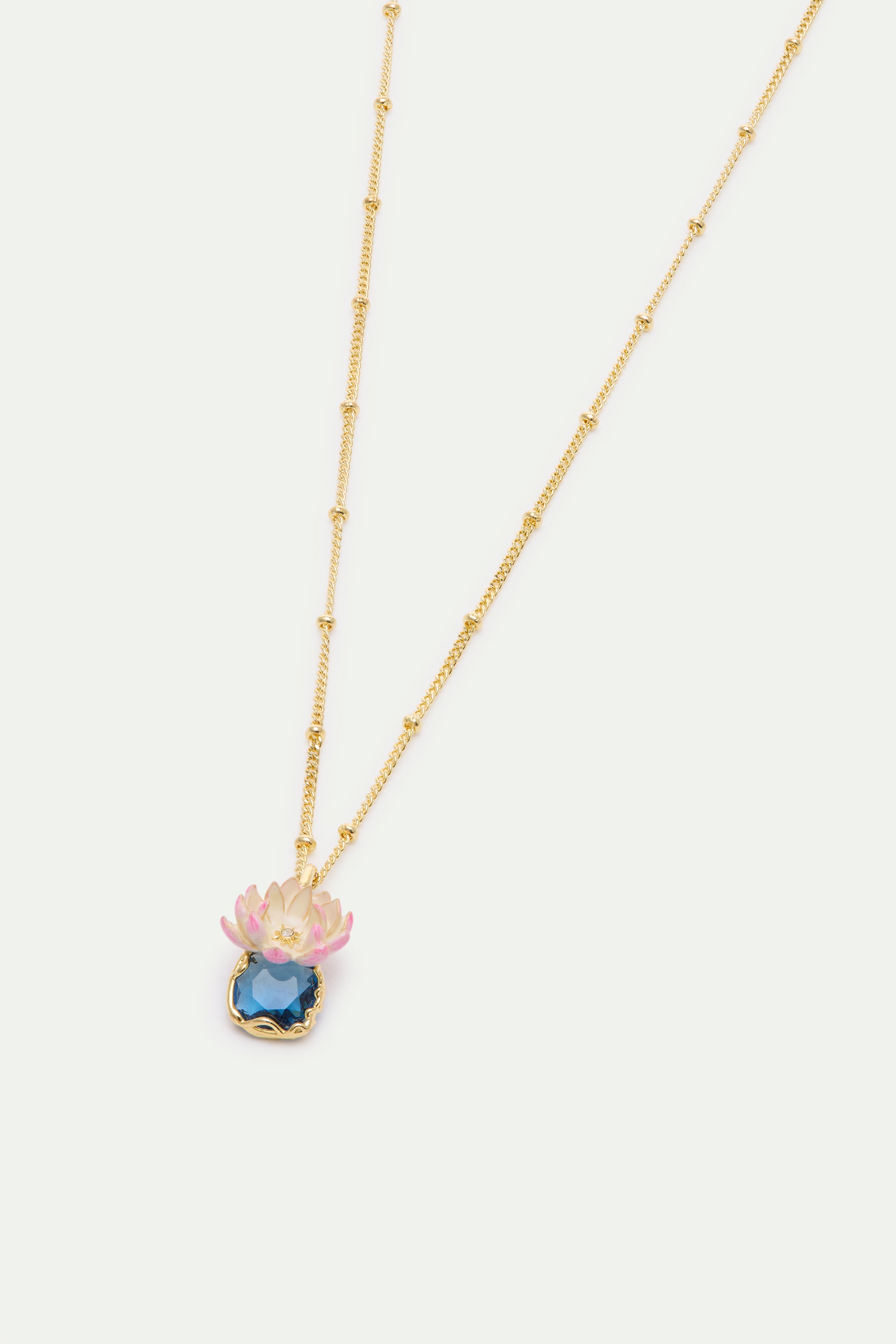 Gold-toned beaded chain necklace with a pendant featuring a pink and white lotus flower above a large, faceted deep blue gems