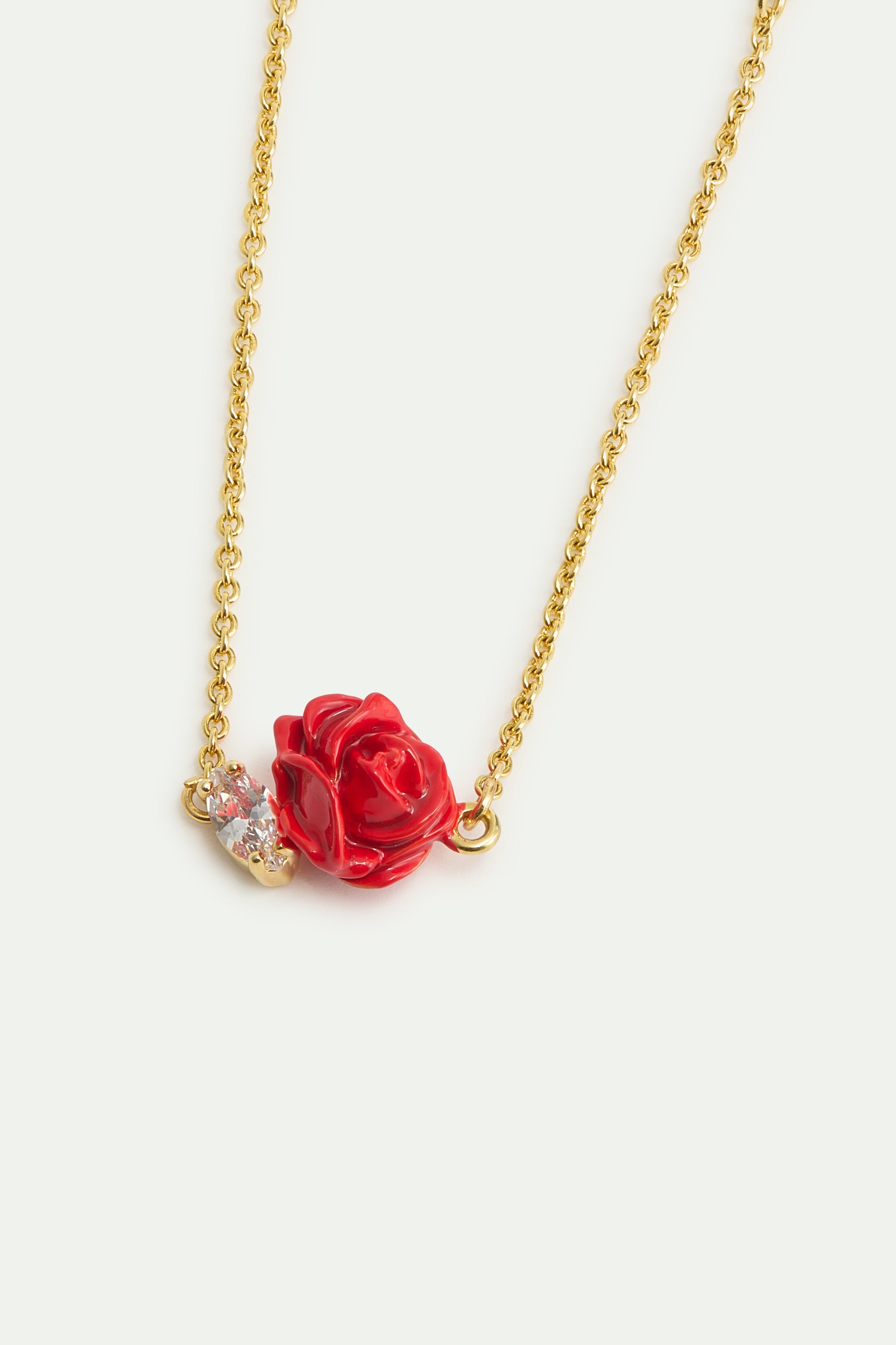 Gold-toned chain bracelet with a red enameled rose charm and a marquise-cut clear stone.