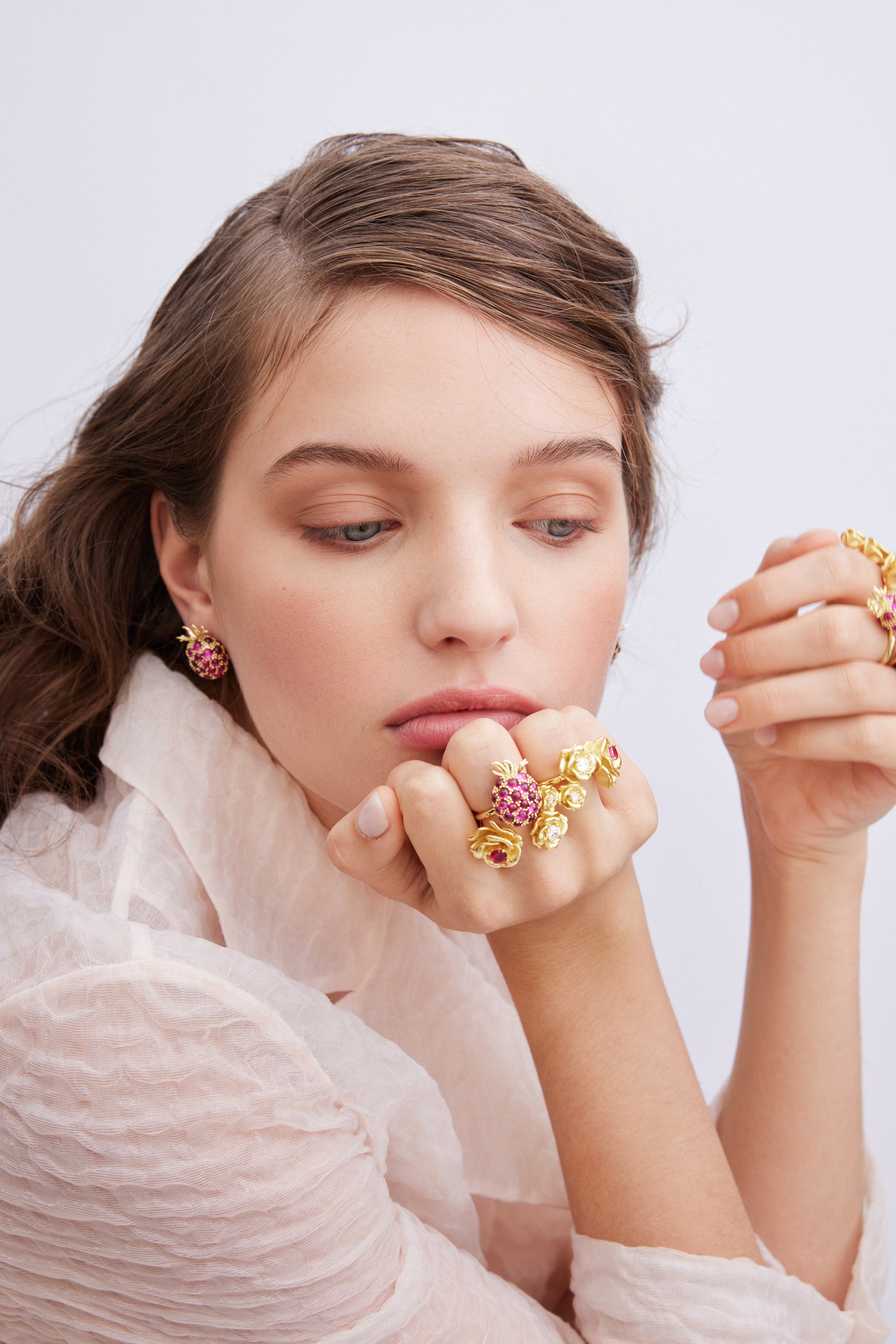 Single gold-toned post earring shaped like a raspberry, covered in small dark pink stones, with a green leaf top.