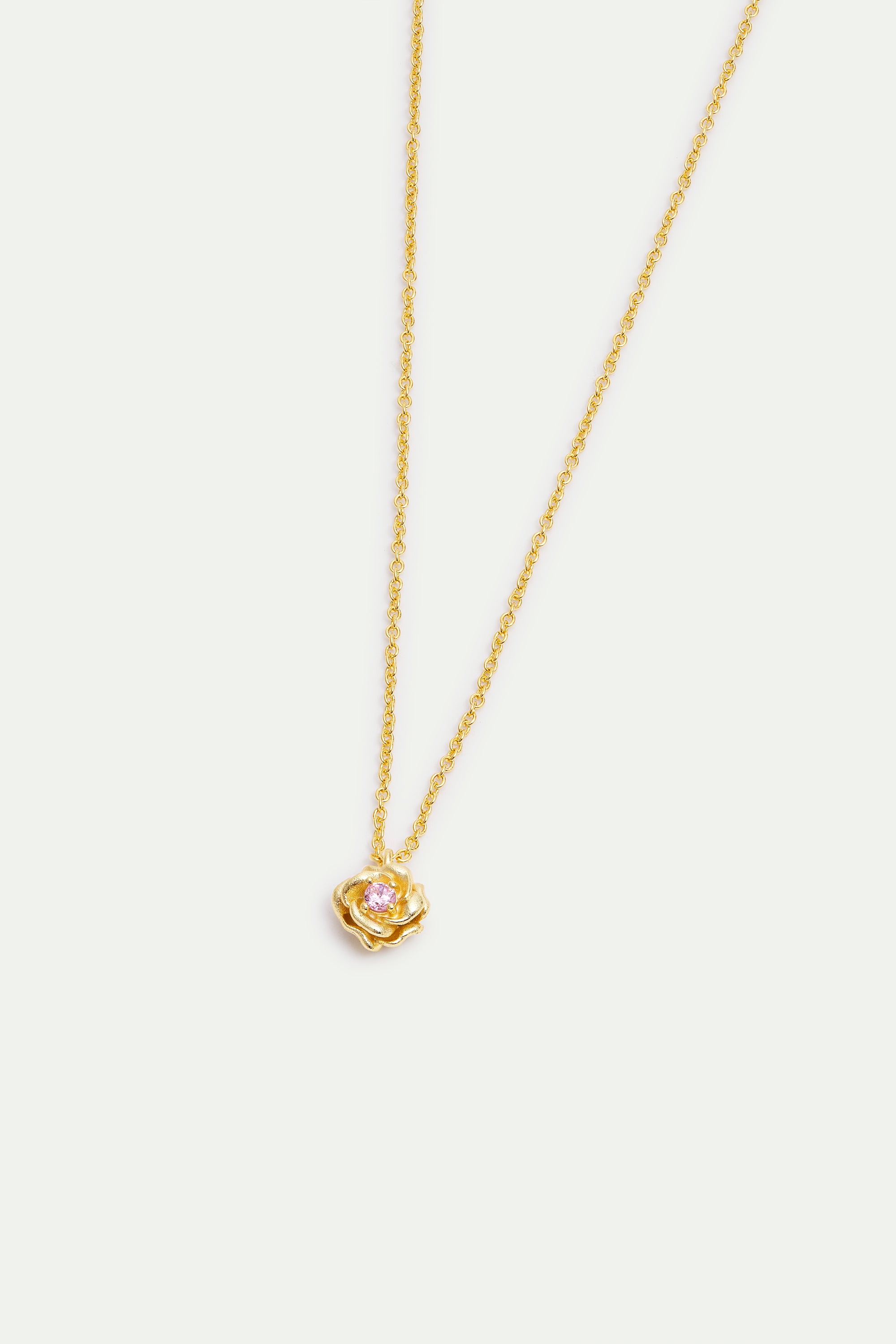 Gold-toned necklace with a delicate link chain and a rose-shaped pendant featuring a small, round pink stone in its center.