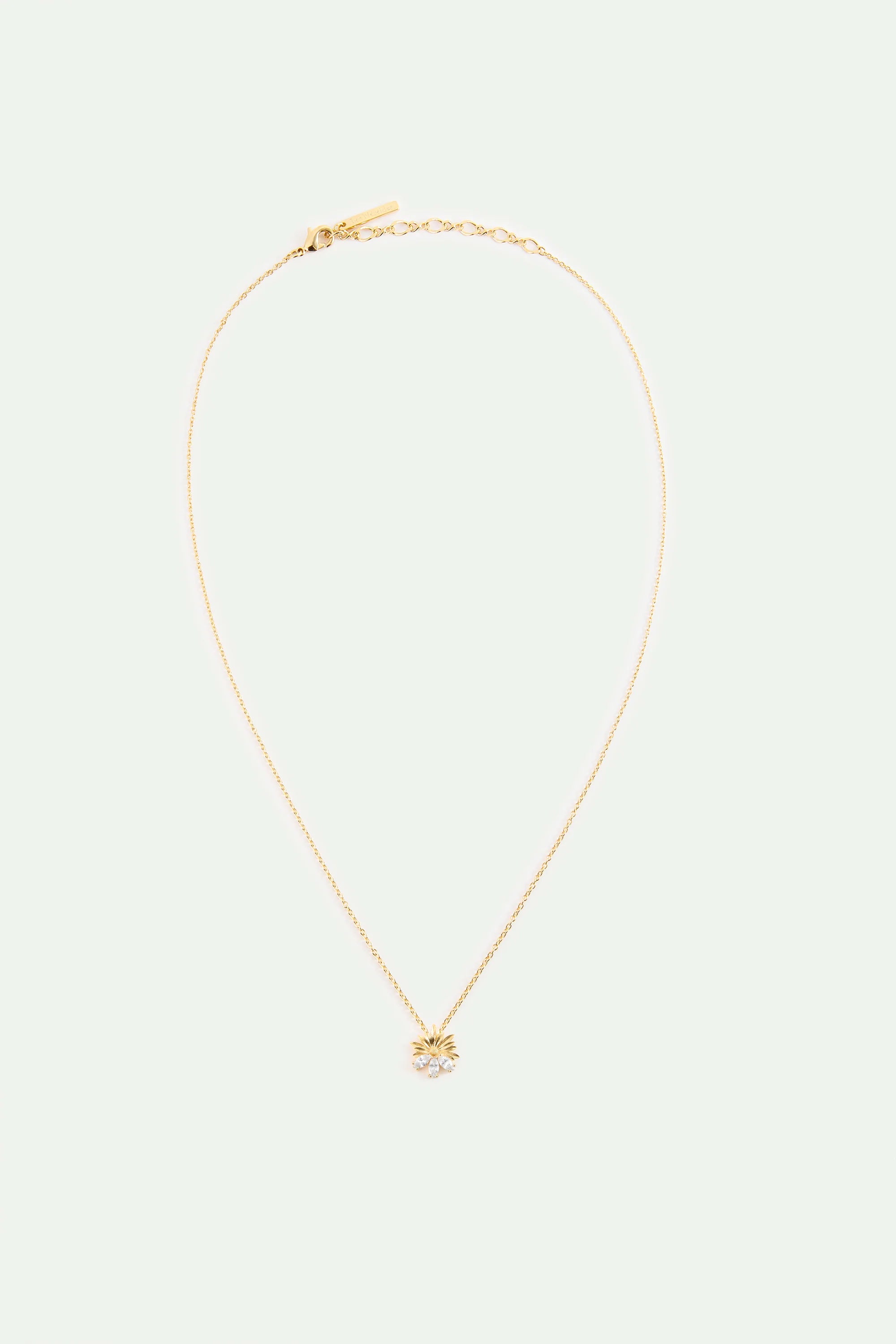 Gold-toned necklace with a thin chain. The pendant is a stylized sun with radiating lines and three clear round stones at the