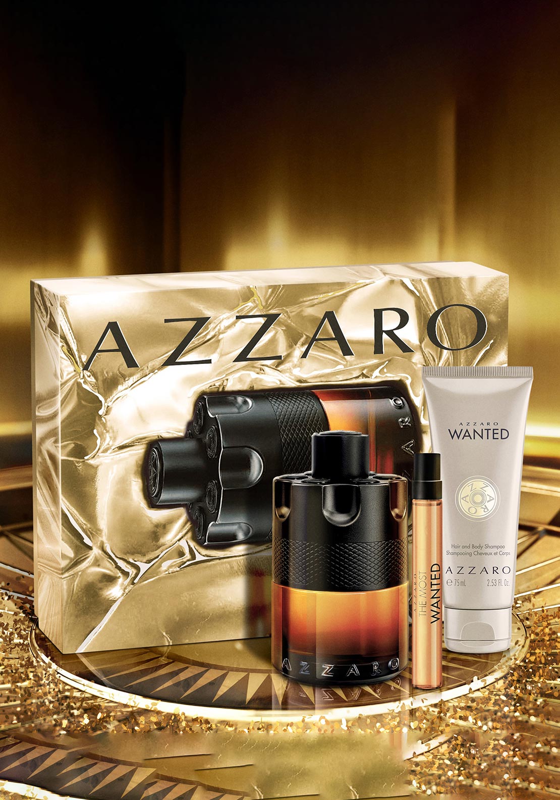 Dark revolver-shaped perfume bottle with amber gradient, a small amber vial, a beige shampoo tube, and a gold-toned textured