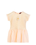 Front view flat-lay studio shot of the Aigner Kids baby girls pale peach short-sleeve dress, highlighting the textured metallic gold thread bodice and central horseshoe logo patch.