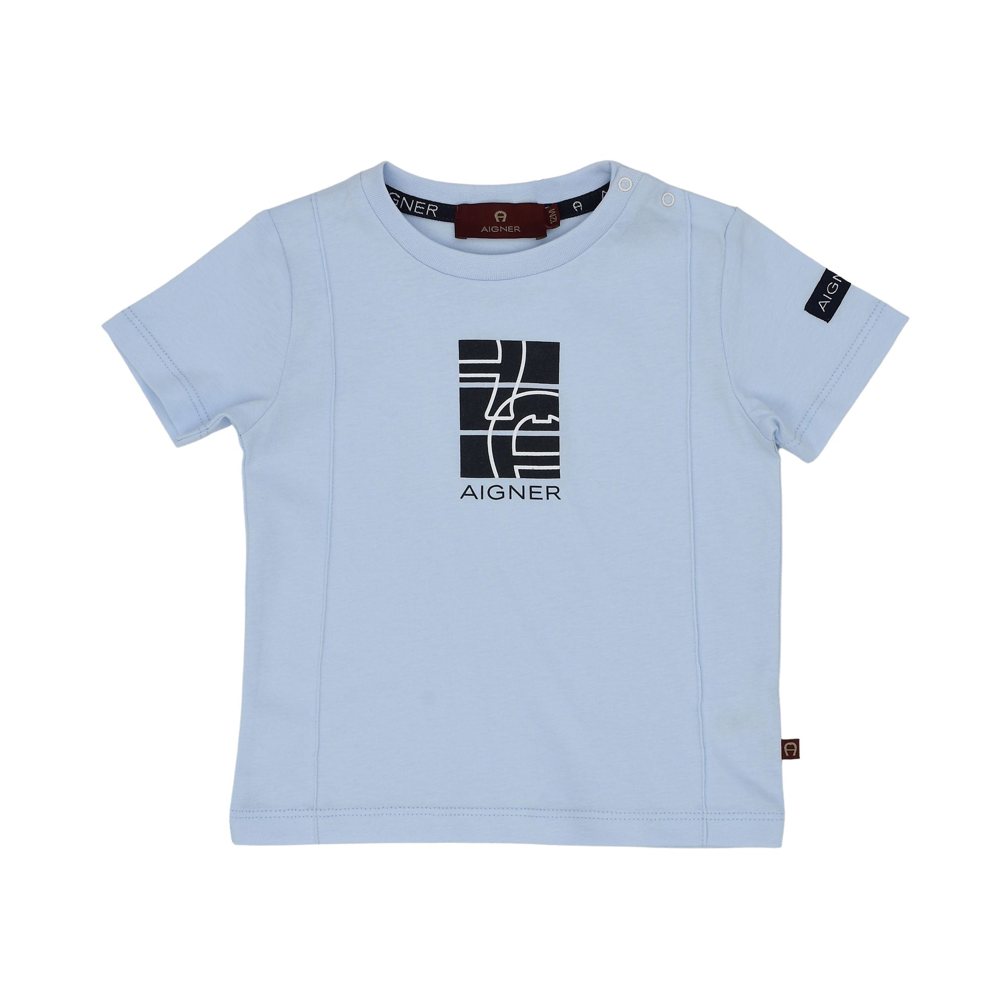 Close-up of the light blue T-shirt's chest graphic, featuring the navy and beige geometric horseshoe design.