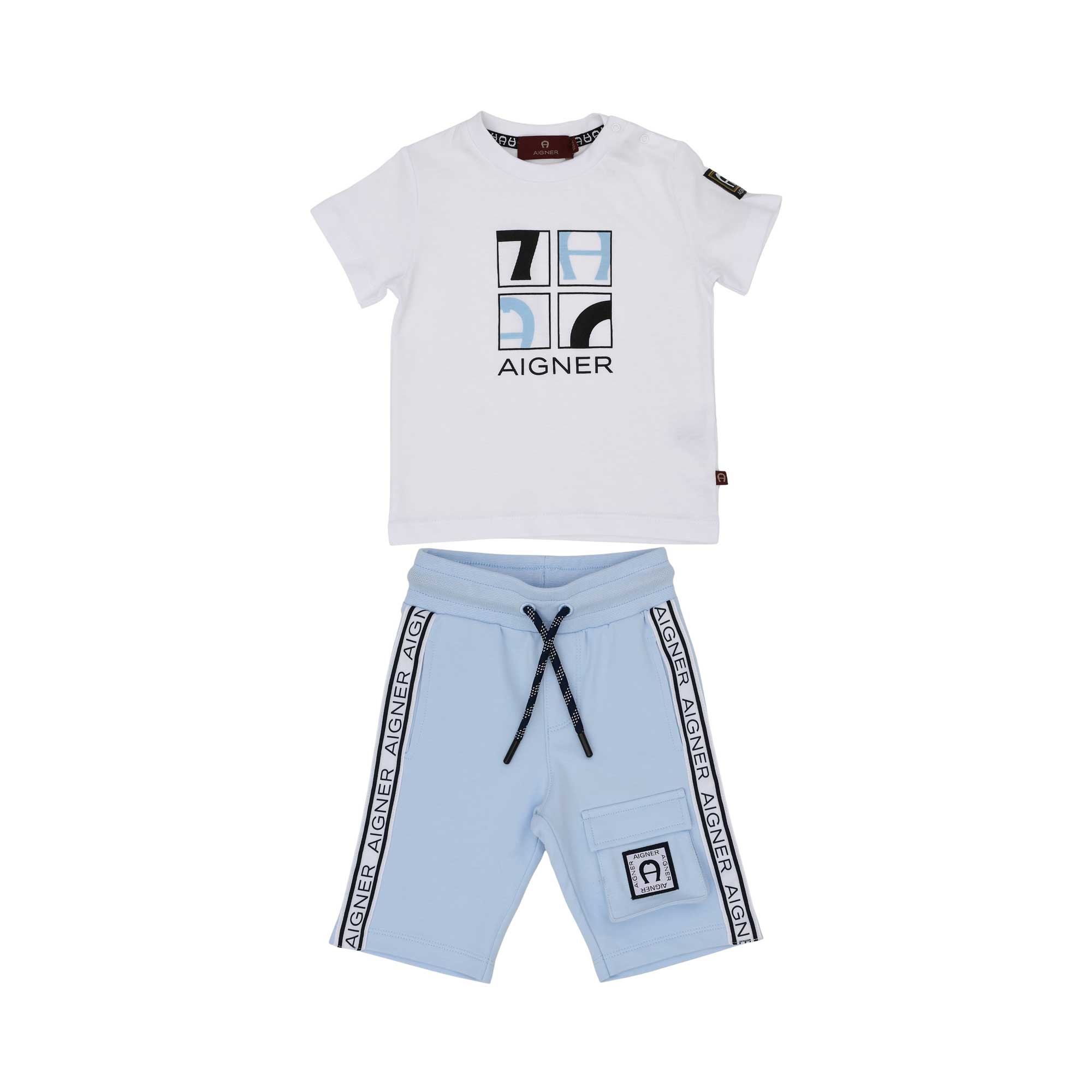 A boys' designer outfit by Aigner Kids featuring a white graphic T-shirt and light blue shorts with logo-tape detailing.