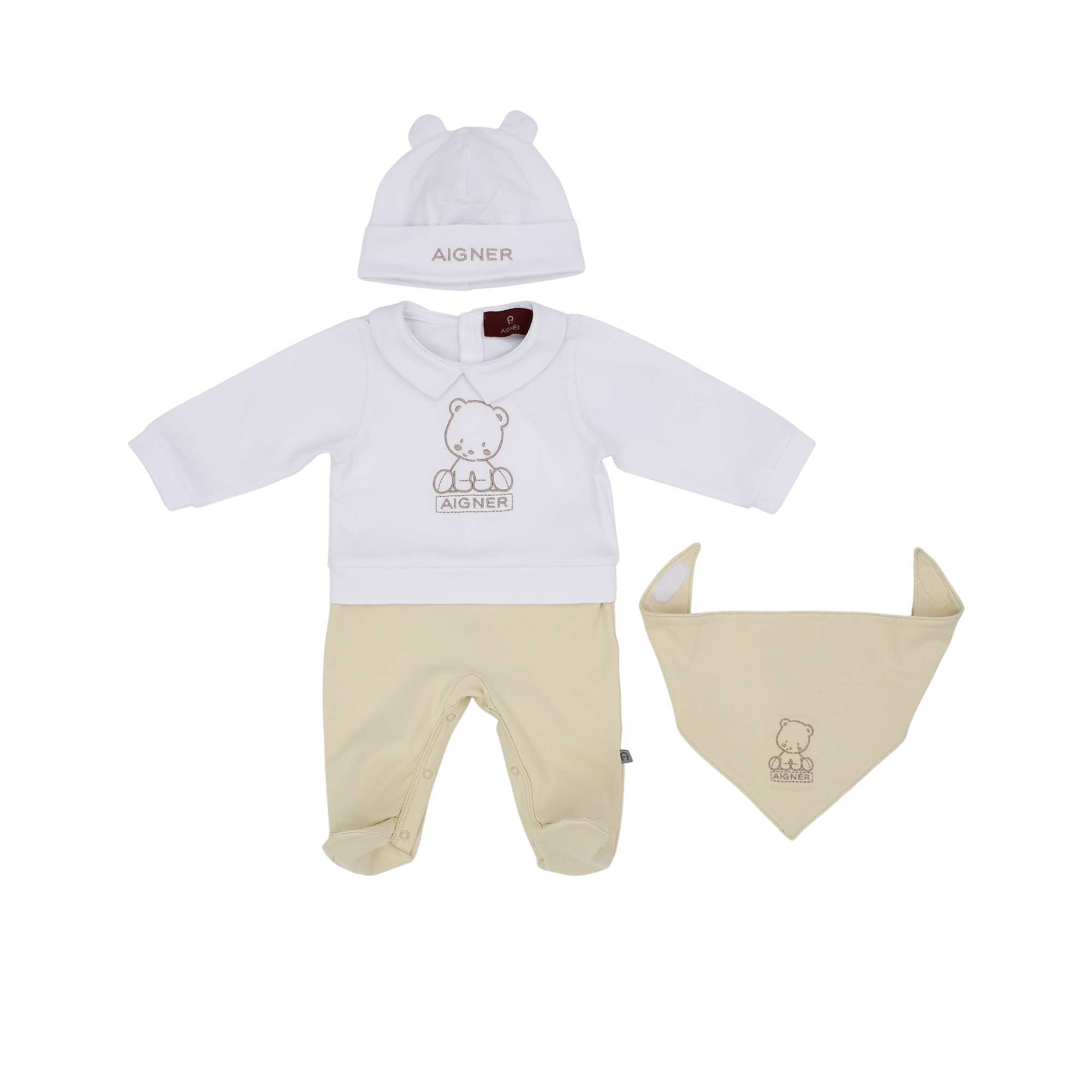 Front view of an Aigner 4-piece baby set featuring a white long-sleeved top with a teddy bear logo, beige footed leggings, a white beanie with ears, and a beige triangular bib.