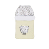 Front view of a cream Aigner Kids baby nest showing a bear-shaped applique with a wagon print, matching printed hood with 3D ears, and the Aigner brand name