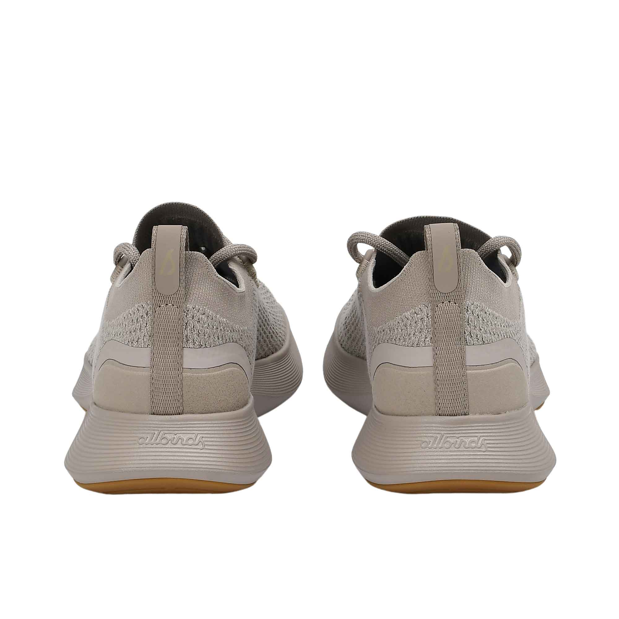 Rear view of the heels of the Allbirds Tree Dasher 2 sneakers, highlighting the flared grey midsole and heel tabs with the embossed logo.