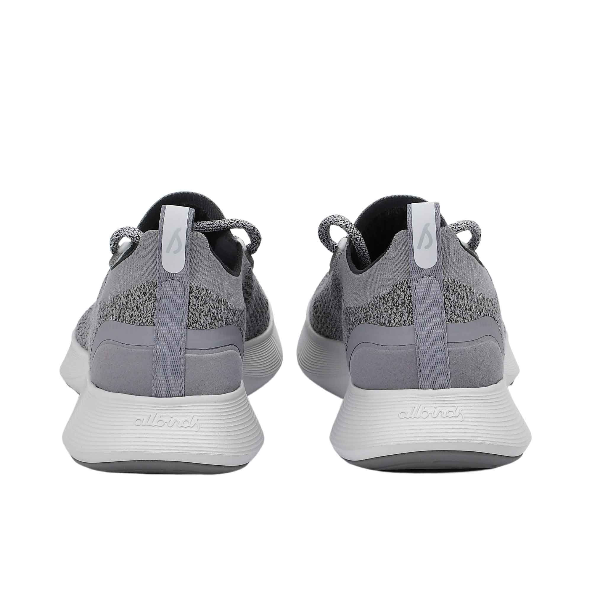 Rear view of the heels of the Allbirds Tree Dasher 2 sneakers, highlighting the flared white midsole and grey heel tabs with the embossed logo.