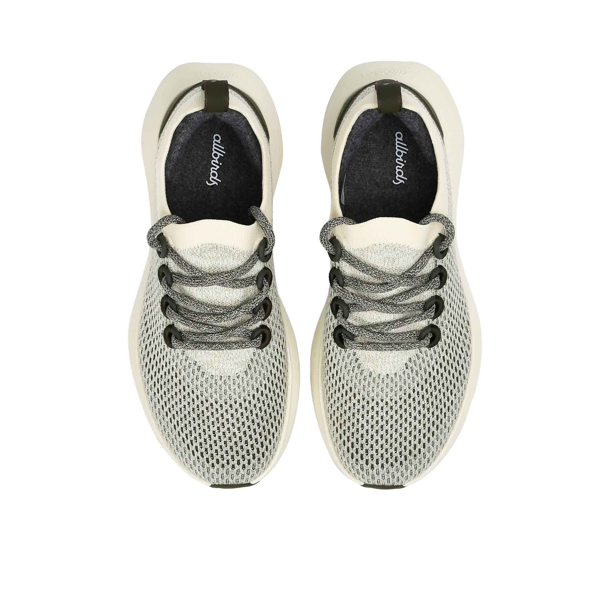Top-down overhead view of the sneakers, displaying the dark charcoal grey insoles printed with the white Allbirds logo.