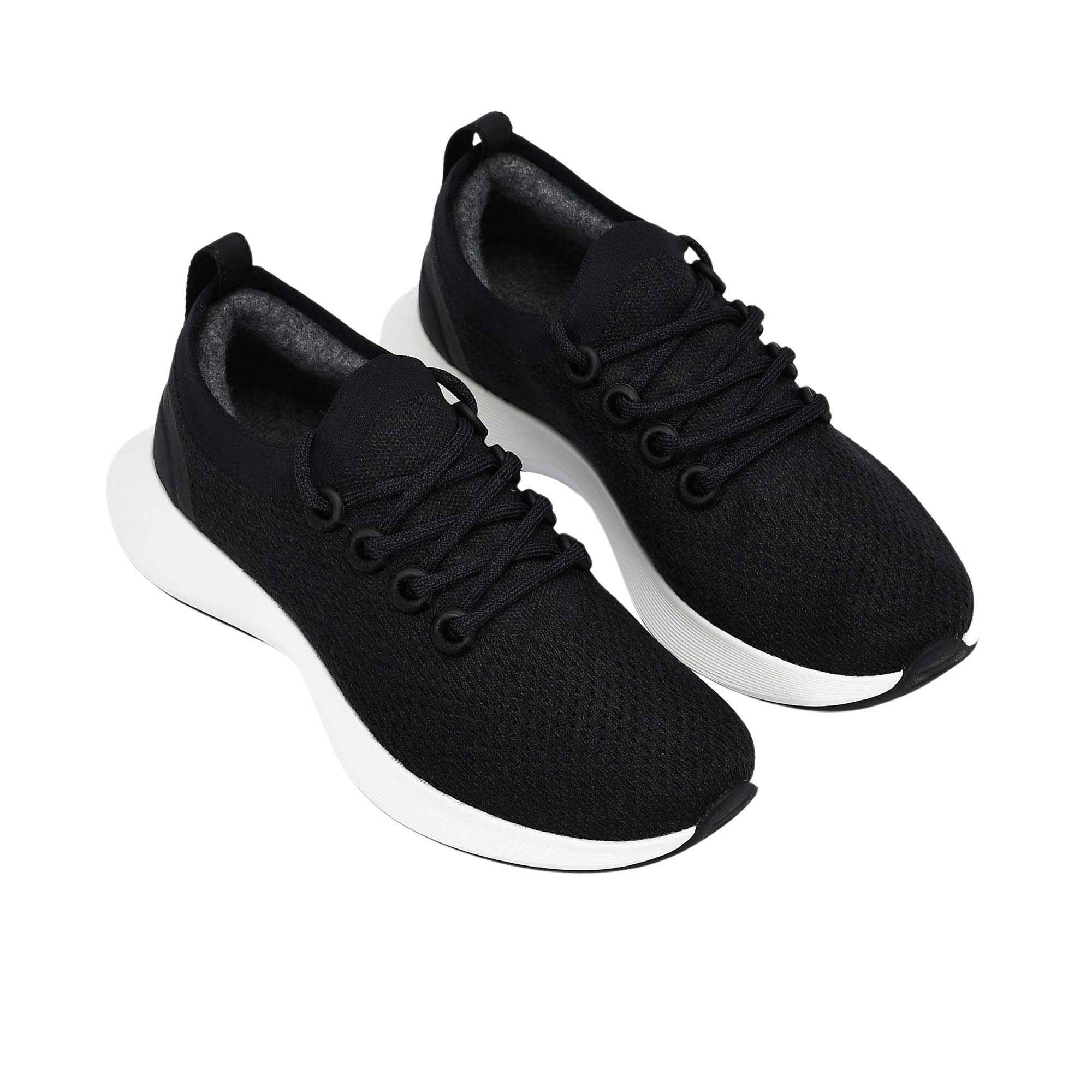 Top-down view of the single white rubber outsole of an Allbirds shoe, displaying a textured black tread pattern on the heel and forefoot sections for traction.