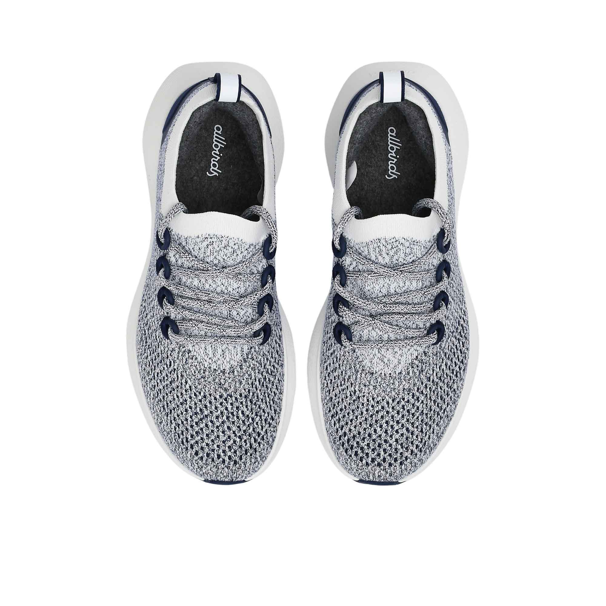 Top-down overhead view of the navy and white sneakers, displaying the dark grey insoles printed with the white Allbirds logo.