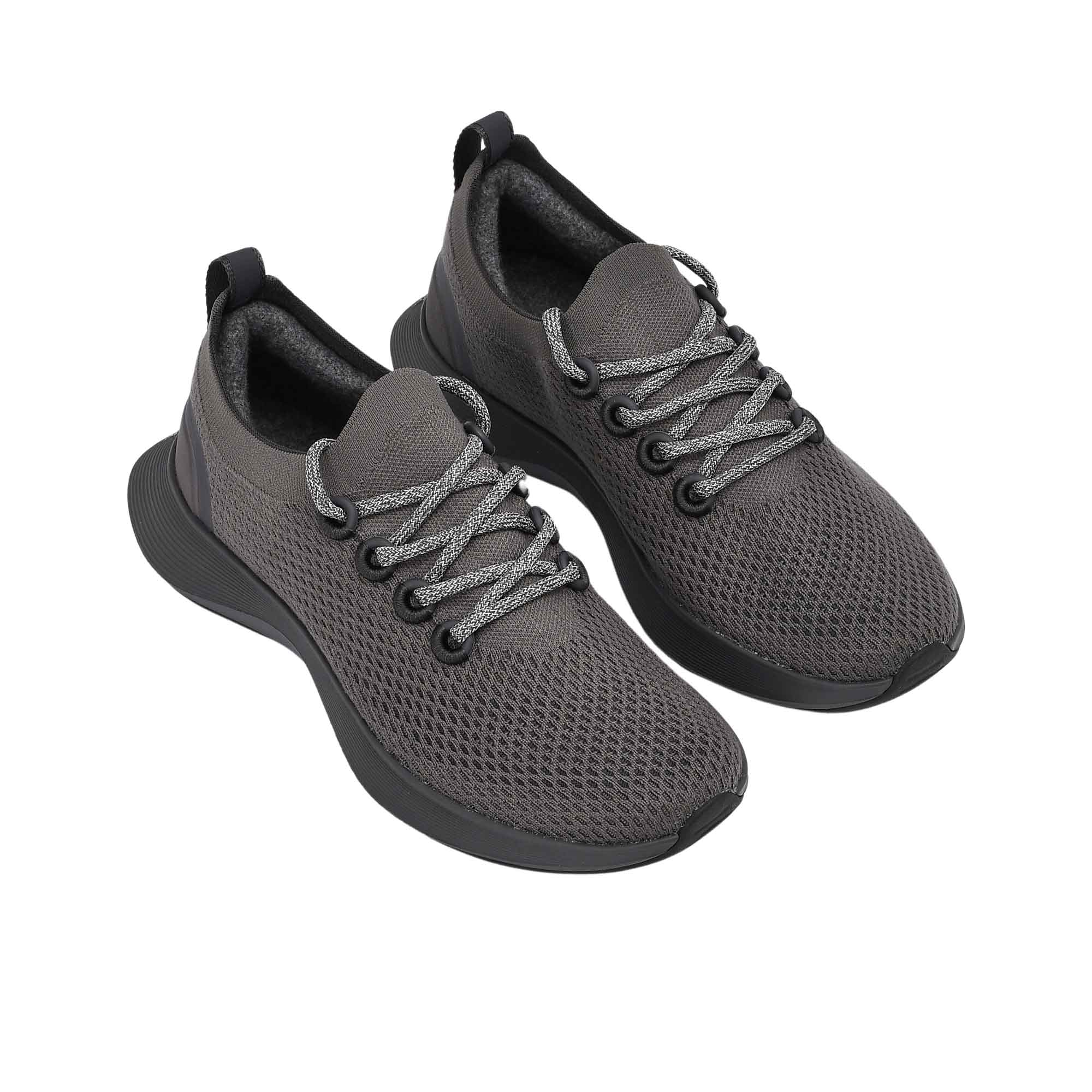 Three-quarter perspective of a pair of charcoal grey Allbirds Tree Dasher 2 shoes, highlighting the textured knit upper, matching laces, and sock-like collar.