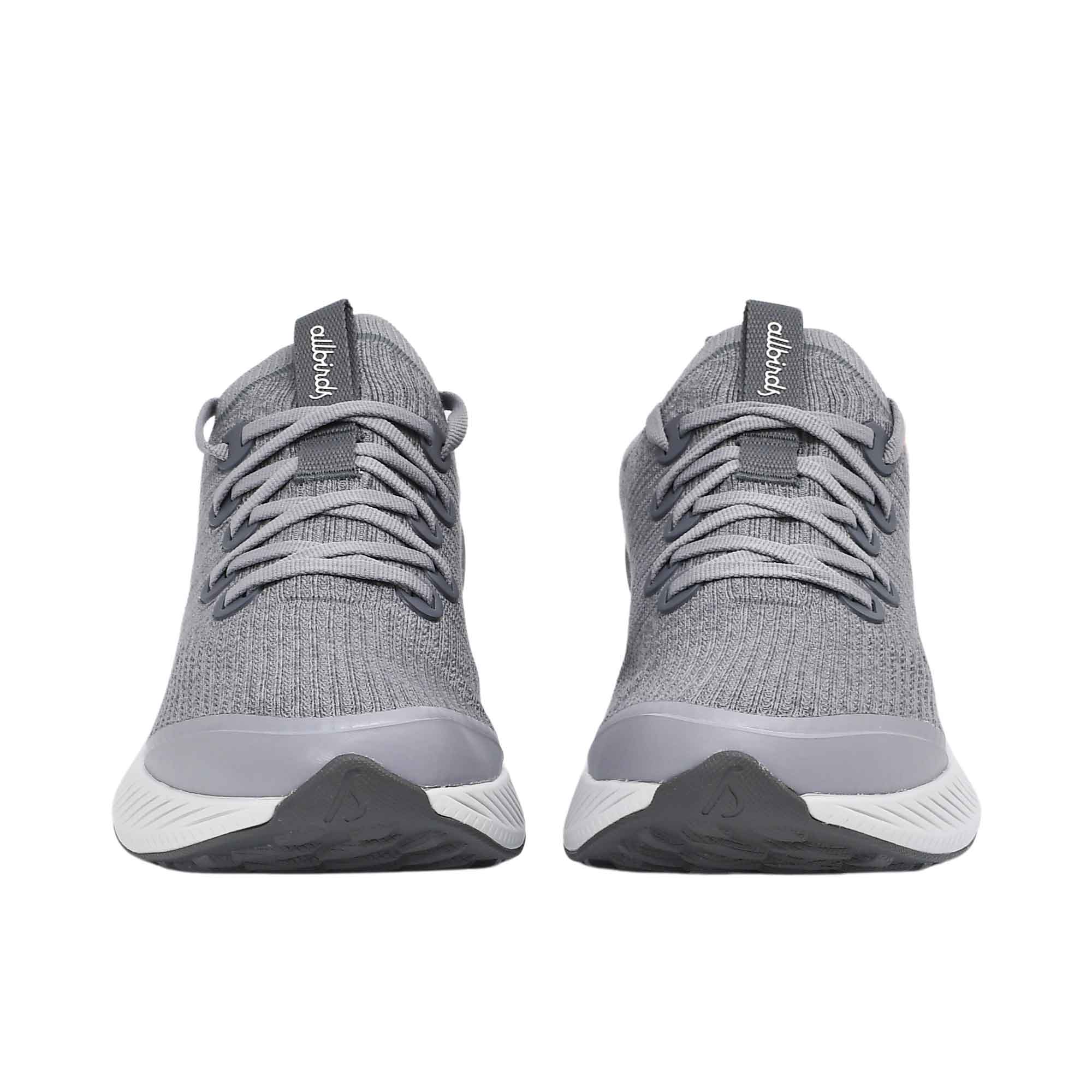 Gray athletic shoes with white soles on a white background.