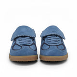 Front view of a pair of blue suede sneakers, highlighting the large, stitched fold-over tongue flaps covering the laces and dark navy overlays on the perforated toe boxes.