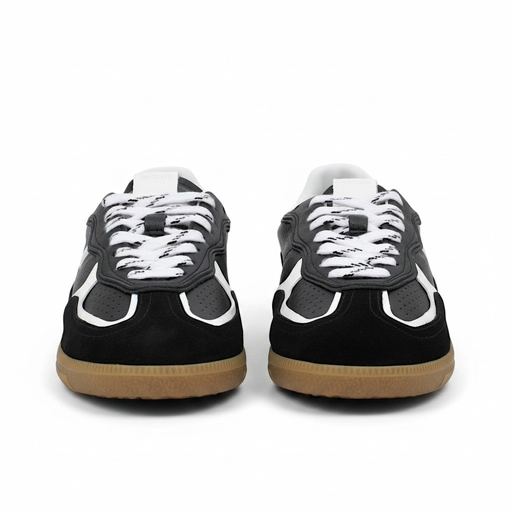 Black and white sneakers with brown soles on a white background.