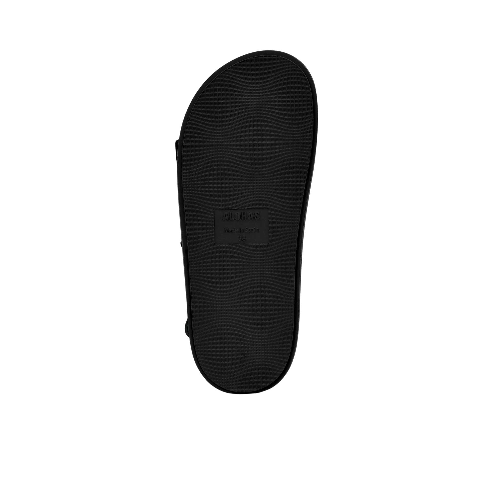 Bottom view of the black outsole of an ALOHAS flat shoe, showing the debossed brand name, "Made in Spain" text, size 37 stamp, and textured non-slip pad.