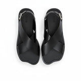 Top-down bird's-eye view of a pair of ALOHAS beige asymmetric strap sandals with printed logos on the insoles.