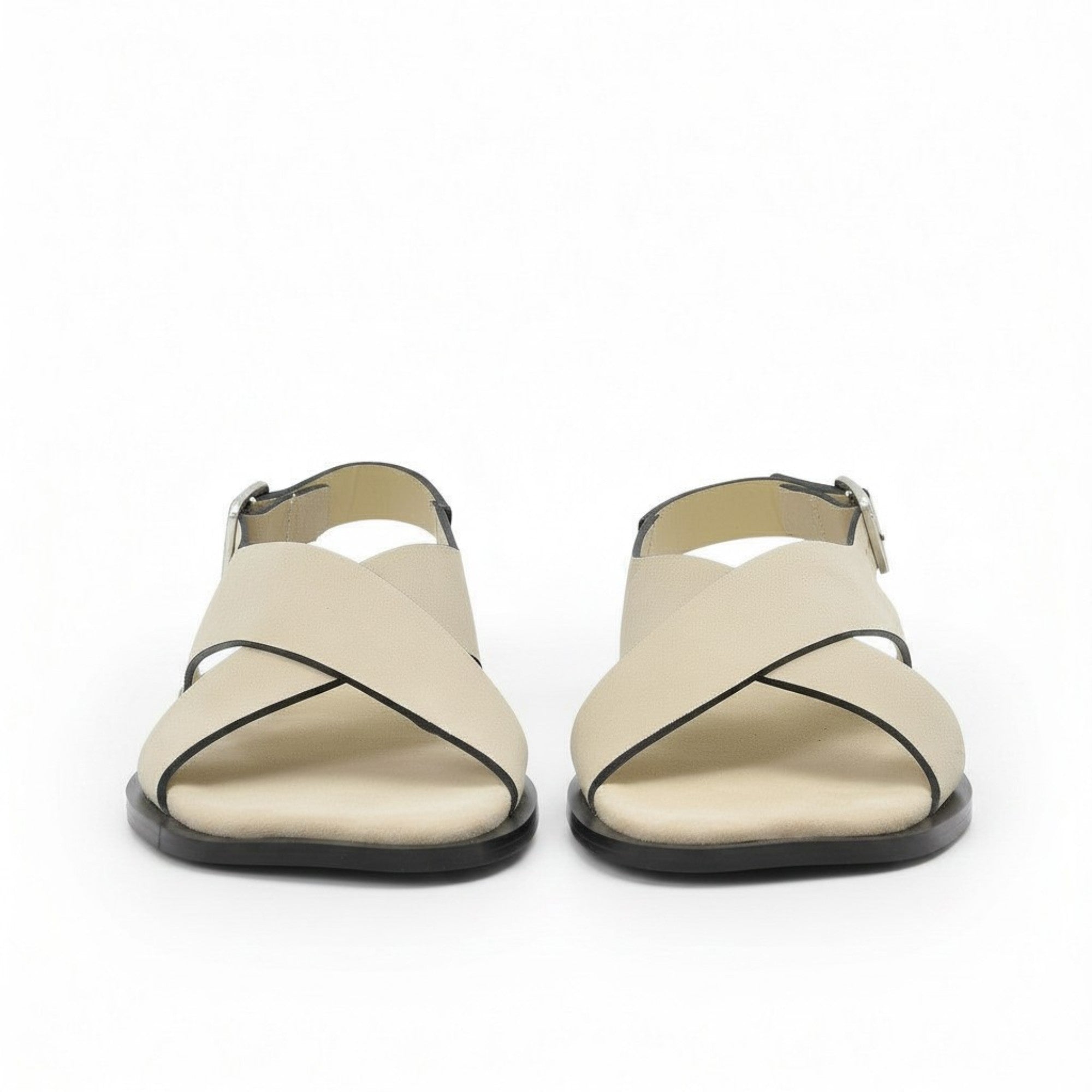 Front view of a pair of ALOHAS beige sandals showing the wide crossover asymmetric straps with fine dark piping.