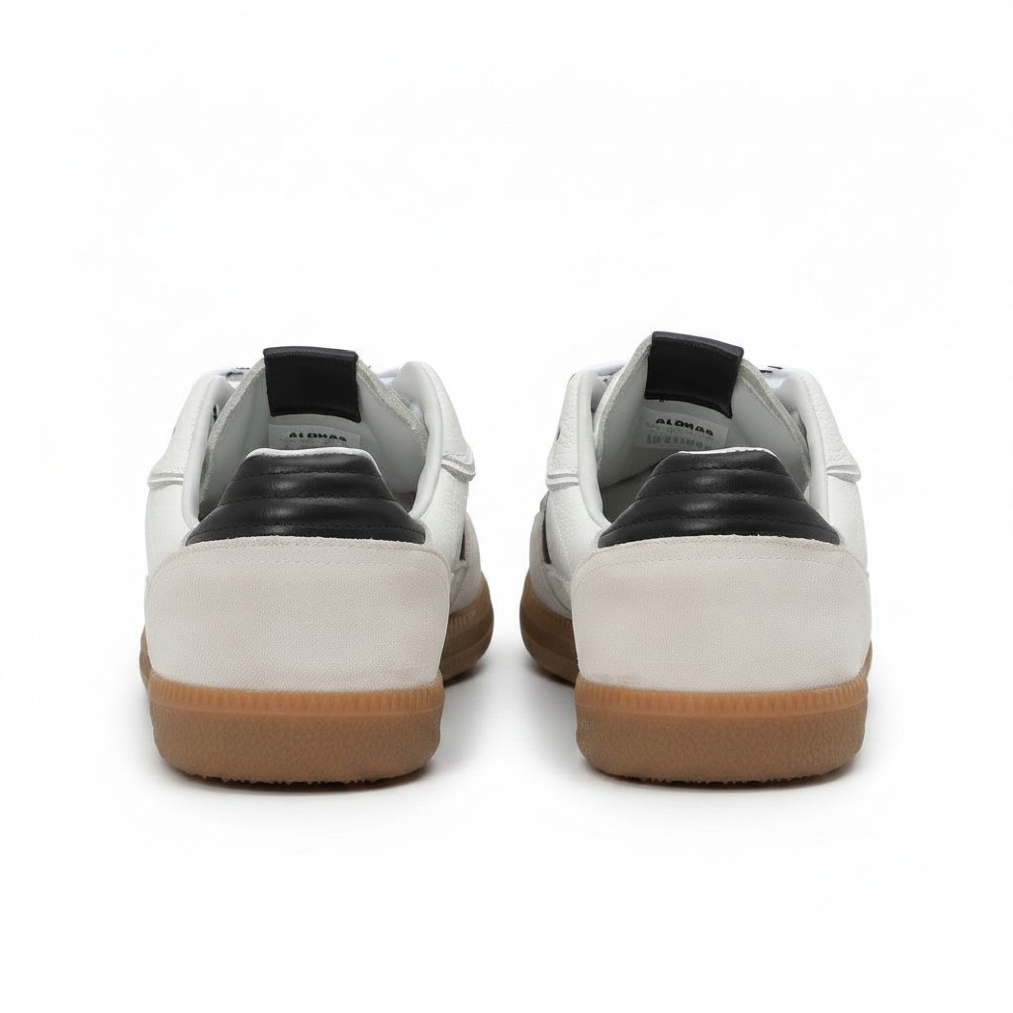 Rear heel view of a pair of ALOHAS sneakers showcasing the contrasting green leather heel tabs and the gum rubber sole border.