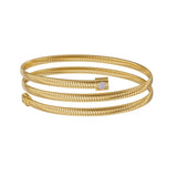 A direct eye-level studio profile of the gold wrap-around Tubogas bangle, highlighting the three distinct levels of polished ribbed metal bands.