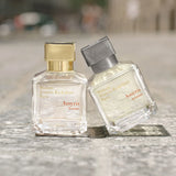 Clear rectangular glass perfume bottle with a gold-toned cap. Contains light yellow liquid. Label reads "Maison Francis Kurkd