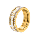 A side-angled studio product photograph of the Escada Eliza 3-in-1 stackable ring, showing how the two outer crystal-pave bands nest with the central white Mother of Pearl monogram logo band.