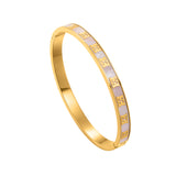 An angled side view of the Escada Eliza hinged bangle, highlighting its polished inner gold finish, slim profile, and the seamless integration of the pink Mother of Pearl inlay around the perimeter.