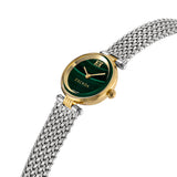 An angled perspective shot of the luxury Swiss Made women's watch, highlighting the polished gold bezel, the fluted side crown, and the natural texture of the green dial face.
