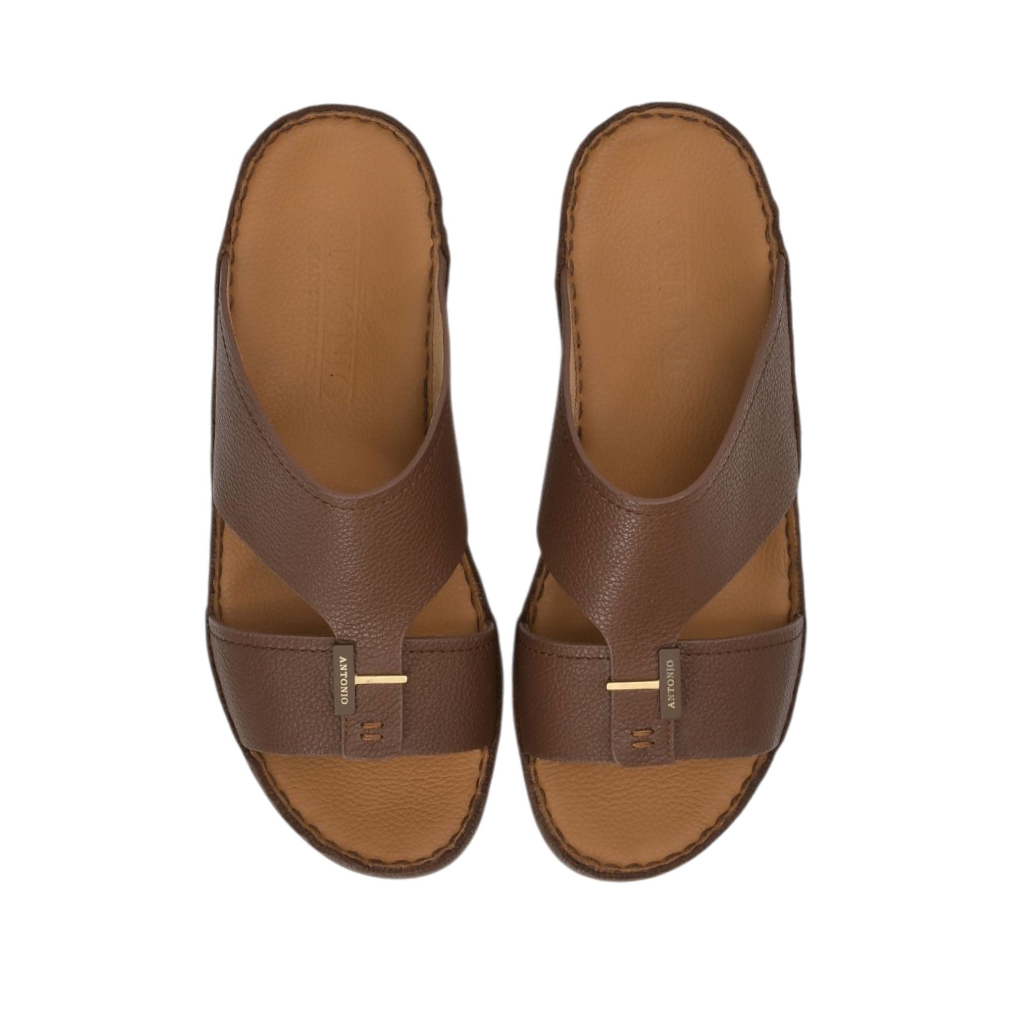 Direct top-down view of a pair of Antonio sandals showing the smooth camel leather insoles cleanly debossed with the Antonio brand name and 'Hand Made in Italy' script against a white background.