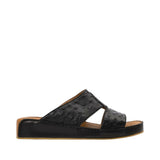 Profile view of an Antonio black leather Arabic sandal, showcasing the ostrich-effect textured cross-strap upper and the tonal leather-covered wedge sole against a white background.