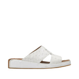 Profile view of an Antonio white leather Arabic sandal, showcasing the ostrich-effect textured cross-strap upper and the tonal leather-covered wedge sole against a white background.