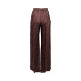 Front view of BAQA wide-leg trousers in a deep rust floral jacquard fabric, featuring a high-waisted pleated design and a relaxed silhouette against a white background.