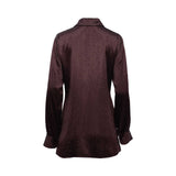 A deep plum satin shirt by BAQA, featuring tonal micro-stud embellishments, a pointed collar, and a slim waist tie against a white background.