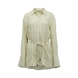 BAQA cream-colored oversized shirt with fine vertical pinstripes, featuring a rope waist tie and wide cuffs against a white background.