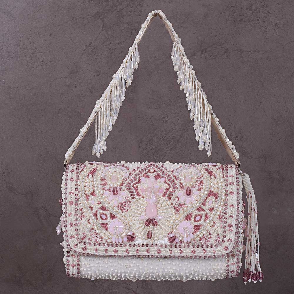 Ivory beaded flapover clutch with intricate rose quartz and ivory beadwork on the flap. Beaded strap with fringes and a side