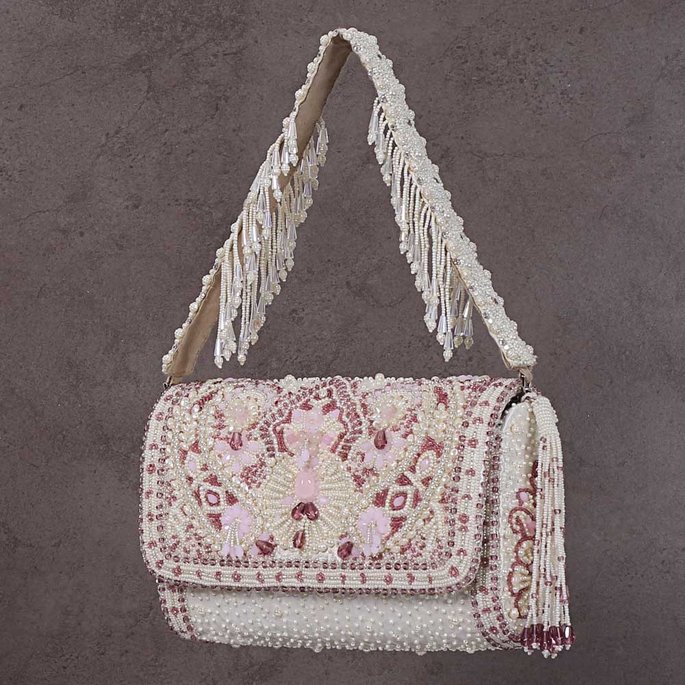 Pristine ivory beaded flapover clutch with rose quartz floral pattern, a beaded tassel, and a fringed beaded shoulder strap.