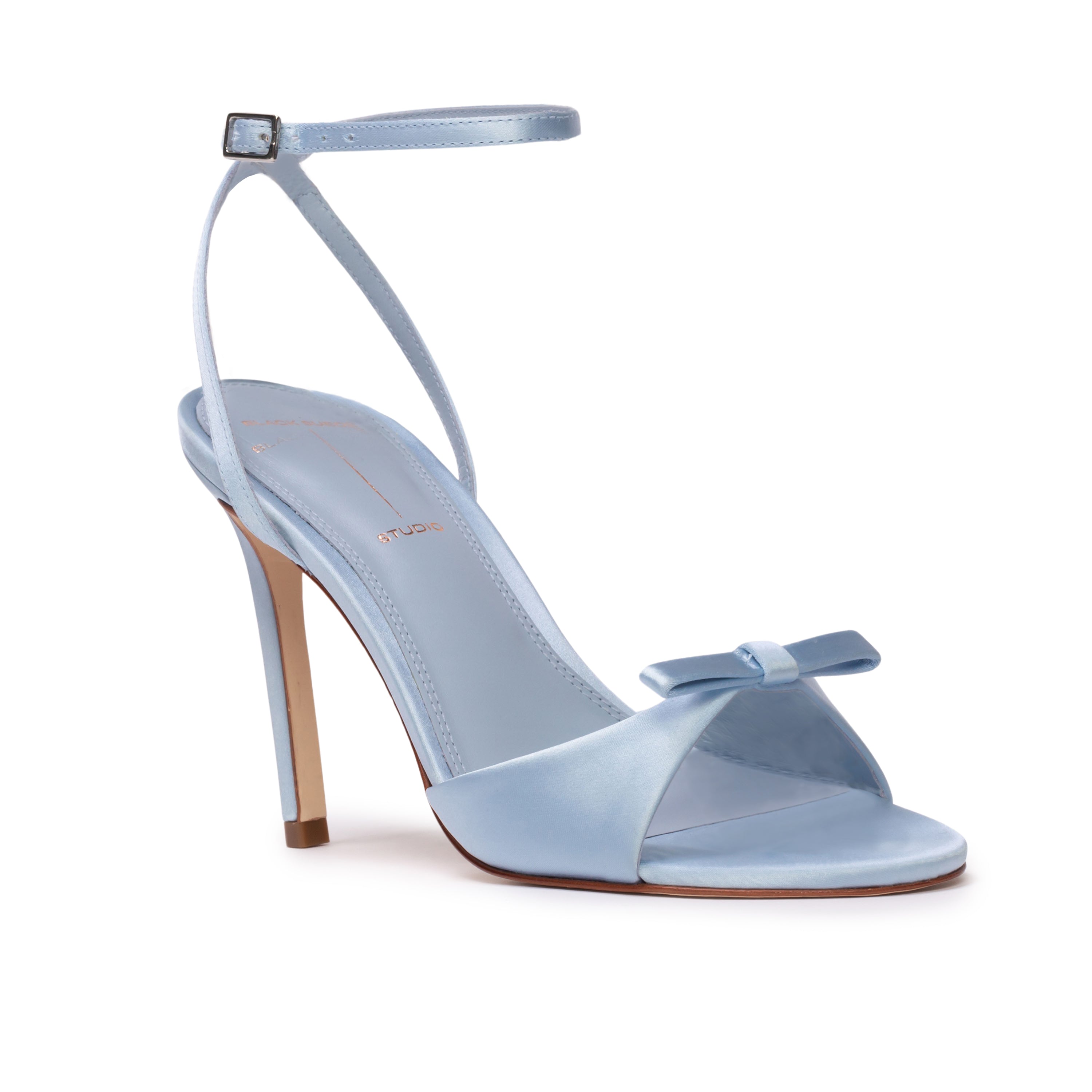 Three-quarter front angle view of the BLACK SUEDE STUDIO Albie 100 blue satin heeled sandal showing the front bow and insole.