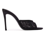 A clean, side silhouette product shot showing the outer side of the black mule, detailing the continuous line from the satin heel cup down to the thin 100mm heel.