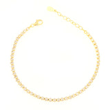 Gold-toned tennis bracelet with a continuous line of clear, faceted stones, a lobster clasp, and an adjustable chain extender
