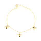 Gold-toned chain bracelet with a lobster clasp and extension chain. Features three black and gold-toned bee charms with clear