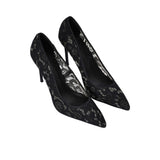 Three-quarter aerial view of the Black Suede Studio lace heels, showcasing the semi-sheer floral pattern and elegant silhouette.