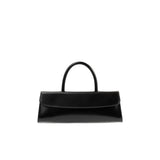 Front view of the BY FAR Mini Longa top handle bag in black semi-patent leather featuring an elongated rectangular silhouette and a single curved handle against a light grey background.