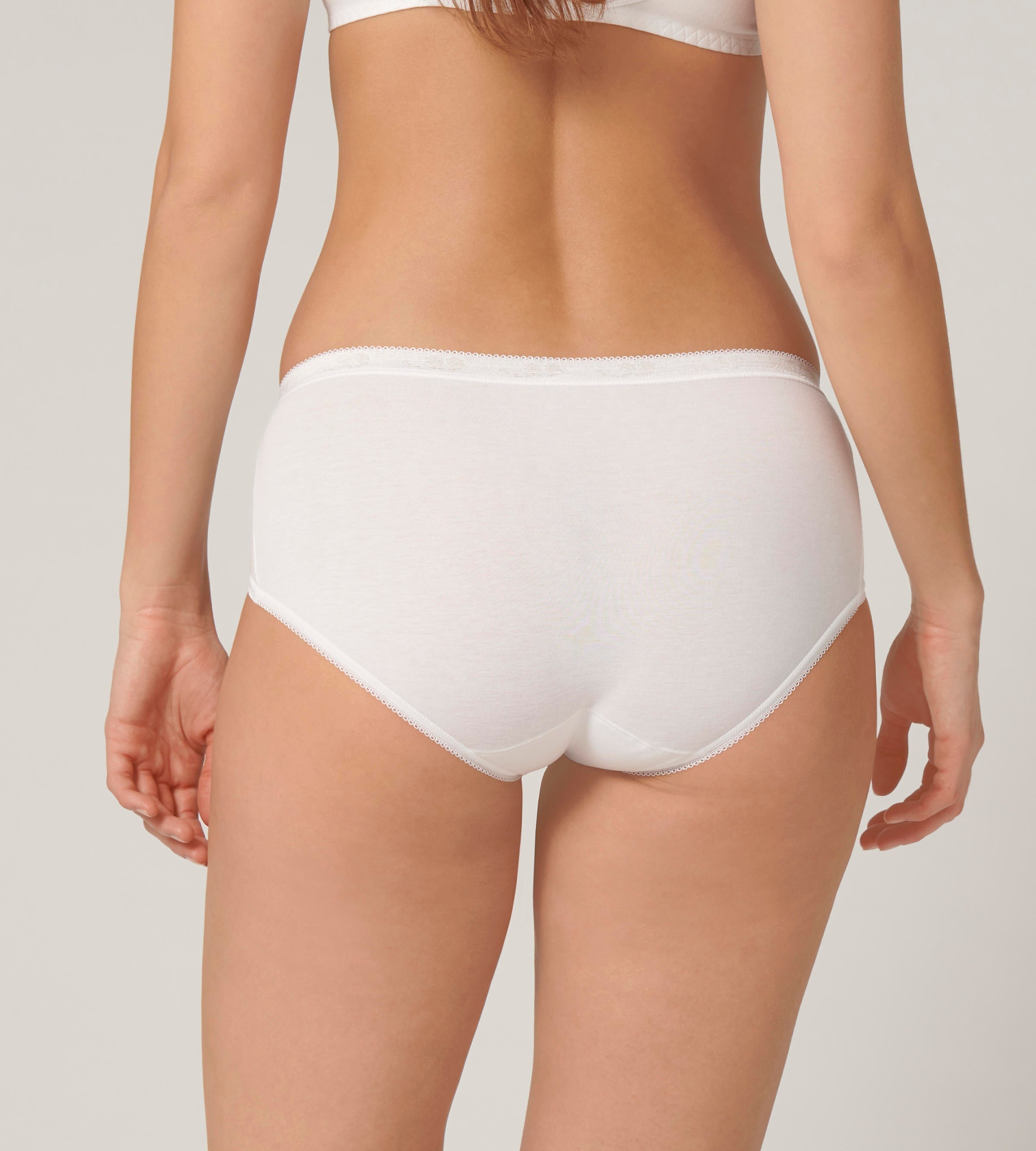 Back view of model wearing the Sloggi Basic+ white midi panties, showing the mid-rise waist and soft, breathable cotton texture. Now Available Online