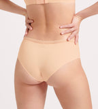 Back view of model wearing the Sloggi Body Adapt Twist hipster panty in powder orange, showcasing the mesh waistband and seamless laser-cut edges. Available Online